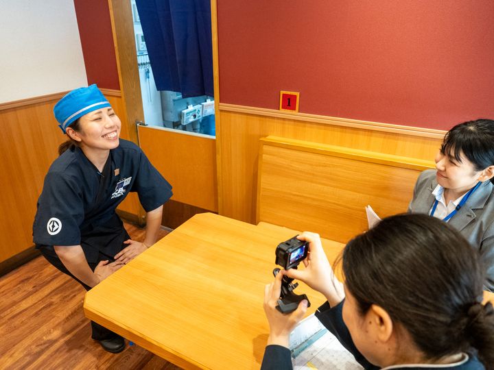 客席で接客を披露する東貝塚店のスタッフ