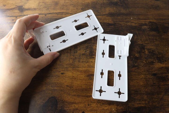 木目調のテーブルで白い仕切り板2枚を手に持っている