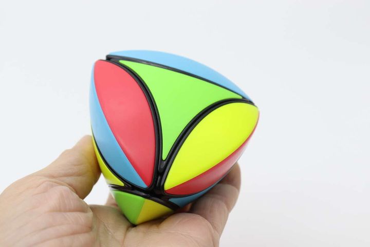 手のひらに乗せられた赤青緑黄色のカラフルな立体パズル