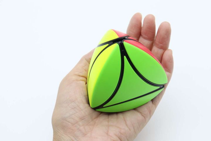手のひらに乗せられた緑と黄色の三角形の立体パズル