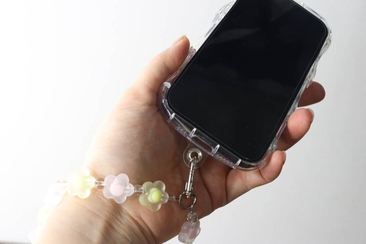 スマホリストストラップを装着したスマホを手に持っている様子