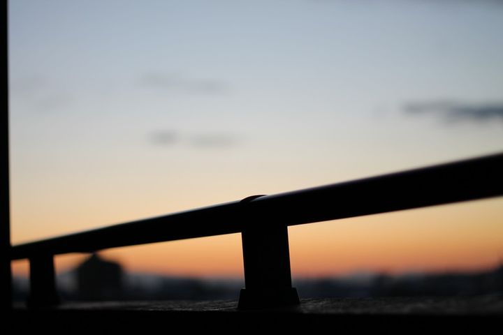夕焼けとベランダの手すり 青とオレンジのグラデーション