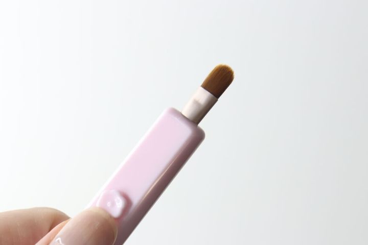 ピンク色のスライド式アイシャドウブラシのブラシ部分が本体から出ている