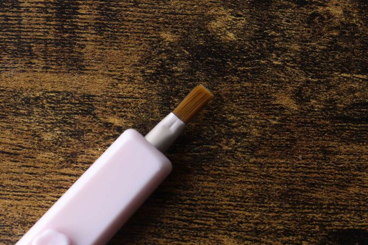 ピンク色のスライド式リップブラシのブラシ部分が本体から出ている状態
