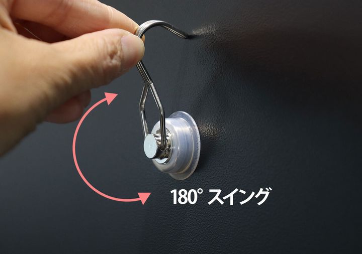 黒い壁に付いた磁石フックが180度スイングする様子を示す矢印