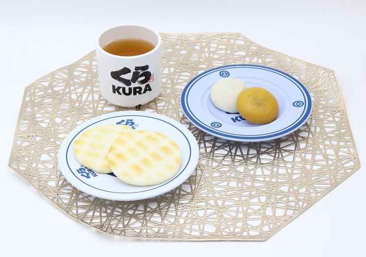 くら寿司の食器に和菓子が盛り付けられ、湯呑みにお茶が注がれている