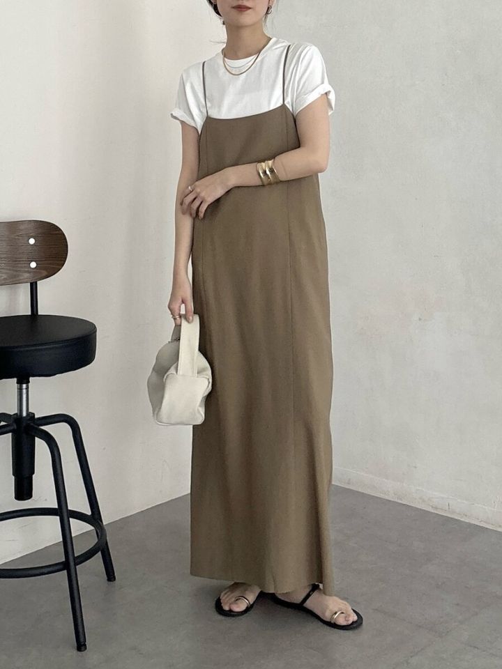 白TシャツとベージュのIラインキャミワンピースを着た女性