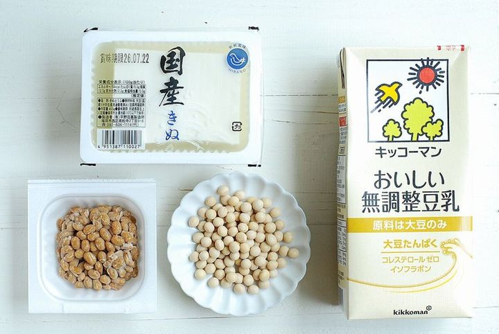 白い木目のテーブルに豆腐、豆乳、納豆、乾燥大豆が並べられた大豆製品の紹介写真