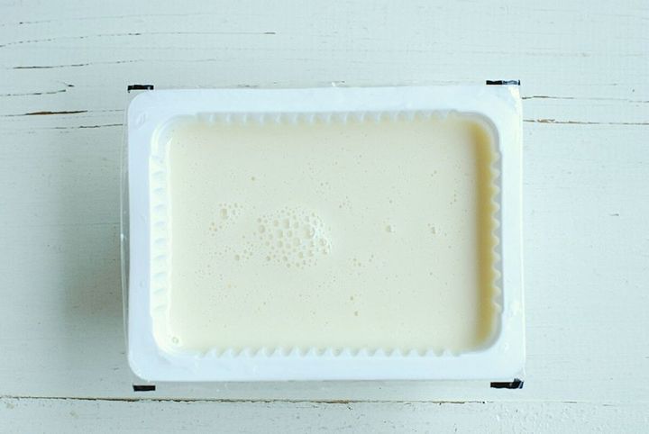 豆腐パックにプリン液が流し込まれ、表面に泡が浮いている状態の俯瞰写真