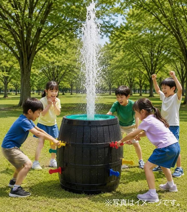 黒い樽形の噴水玩具の栓を子どもたちが引き