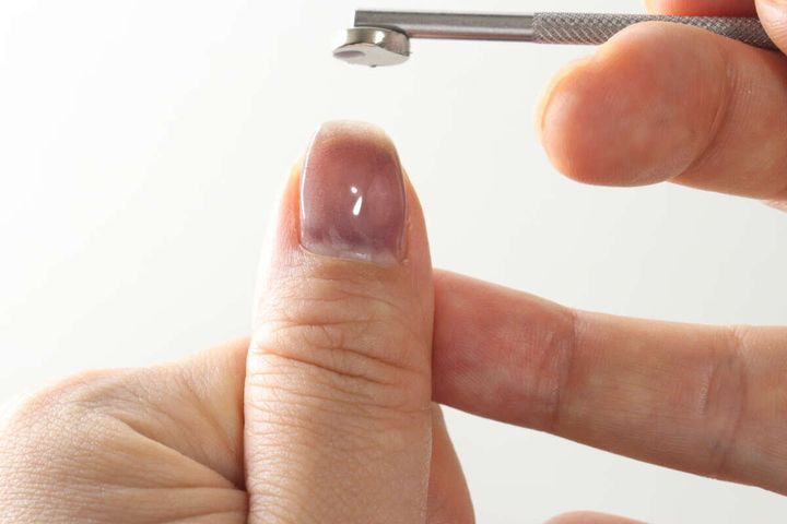 親指の爪の上からマグネットツールで模様を整える