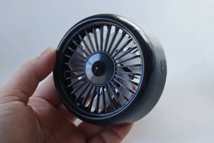 手のひらに乗せられた黒い車載扇風機