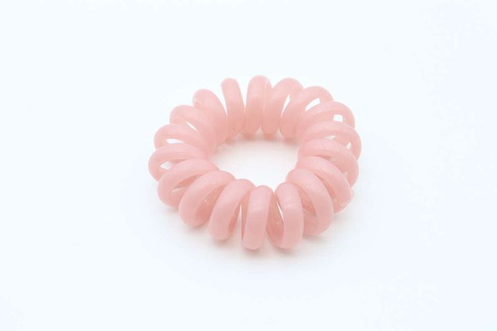白い背景に置かれたピンク色の虫よけスパイラルリング単体。