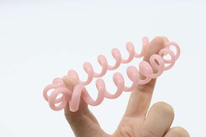 指でピンク色の虫よけスパイラルリングを横に伸ばしている様子。