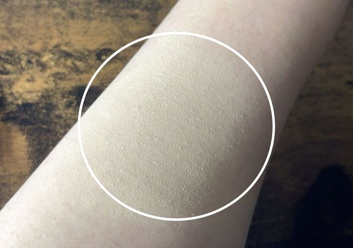 ファンデーションが塗布された女性の腕のアップ。自然な仕上がりで毛穴が目立たない