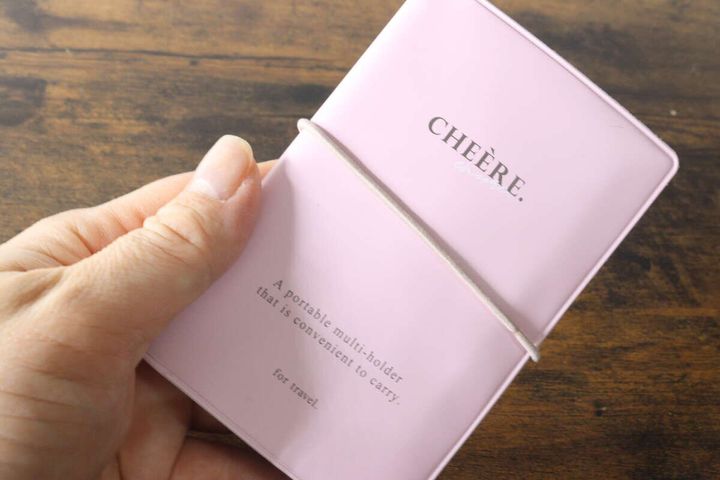 ピンク色のマルチホルダーを手に持ちゴムバンドで留めている