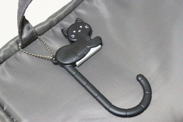 黒い猫型バッグフックがグレーのバッグに付いている