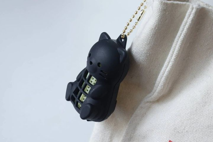 白いバッグに吊るされた黒い猫型虫よけネット
