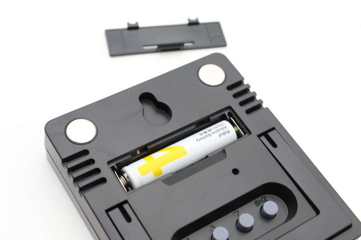 デジタル時計の背面。電池カバーを外し単4電池を入れている。