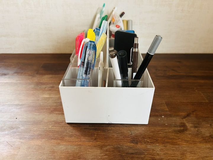 白いペン立てに文房具が種類ごとに整理されて収納されている