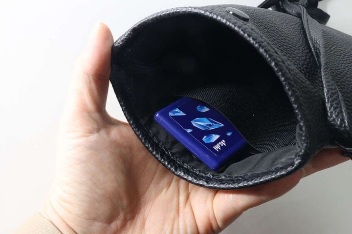 黒いバッグの内側ポケットに青いミンティアが入っている