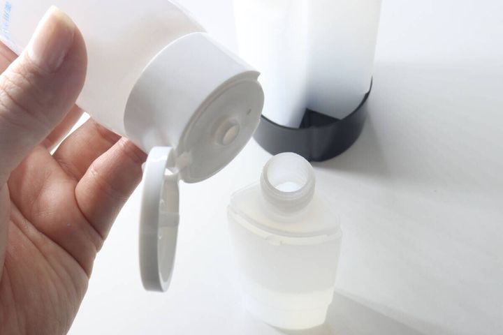 白い詰め替えボトルに化粧水を注ぎ入れている