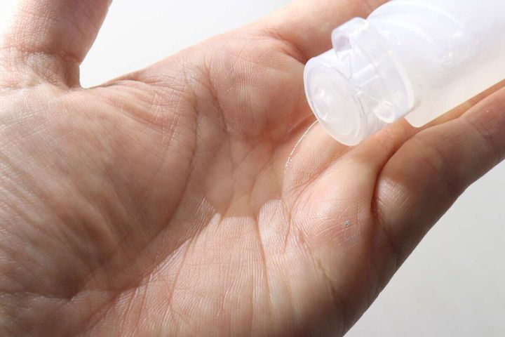 詰め替えボトルから手のひらに化粧水を出す