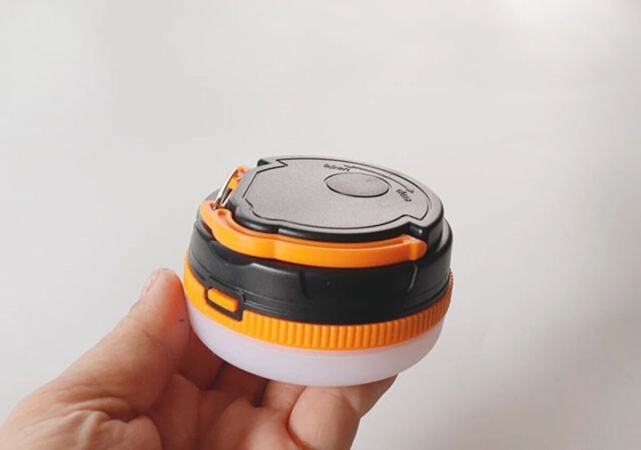 手のひらに乗せた黒とオレンジの小型ランタン