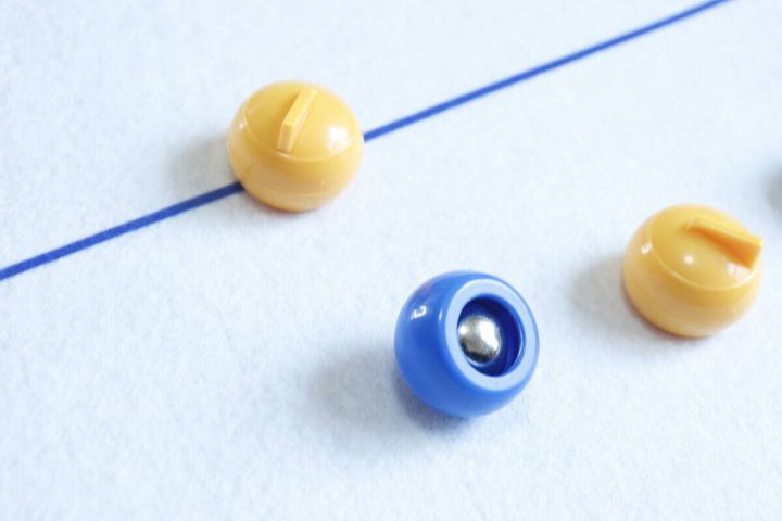 青いカーリングストーンの裏側の鉄玉と黄色のストーン