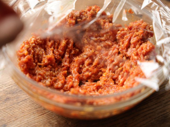 調味料と混ぜ合わせたひき肉をラップで覆い、電子レンジで加熱する準備をしている。