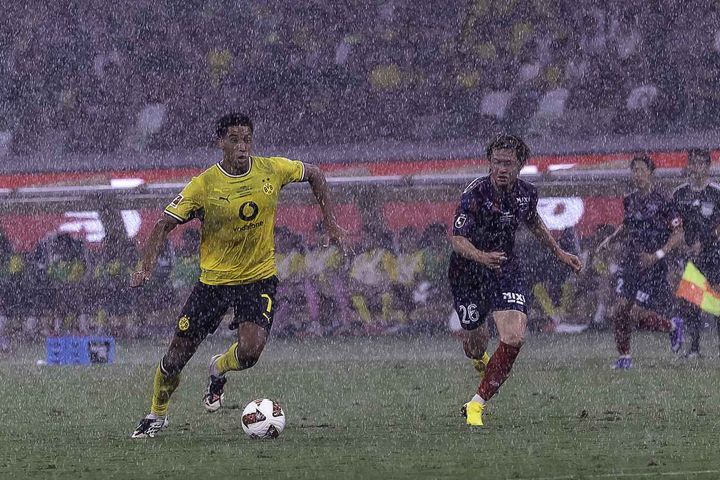 画像: (C)Tomo Sodeyama 豪雨が降りしきる中、ボールを運ぶジョーブ・ベリンガム選手