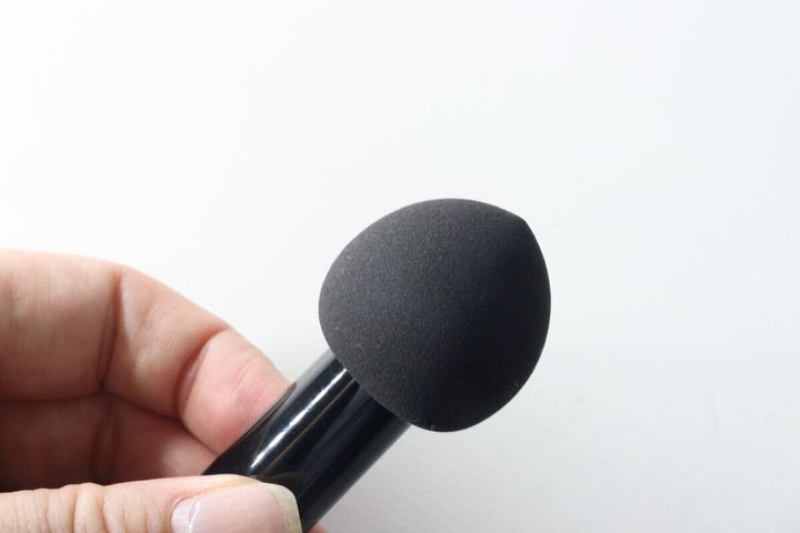 手で持った2WAYブラシのパフ部分のアップ。しずく型でキメが細かい
