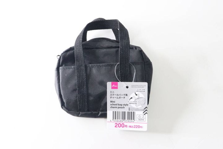 黒いミニスクールバッグ風チャームポーチが商品タグ付きで置かれている