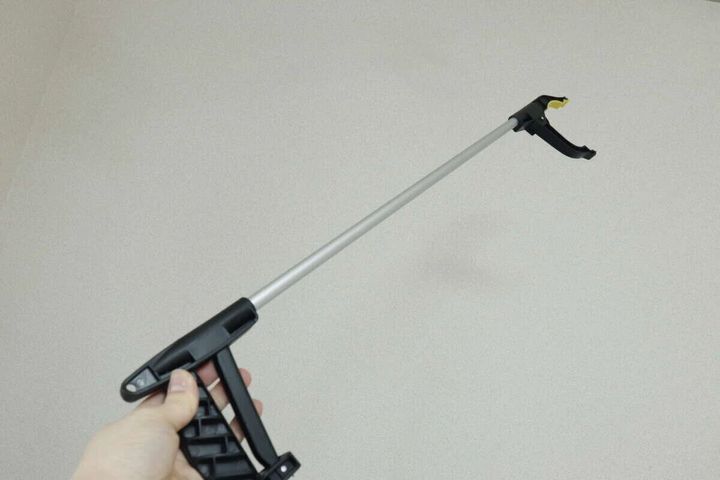 黒いマジックハンドを手に持ち、先端を上に向けている