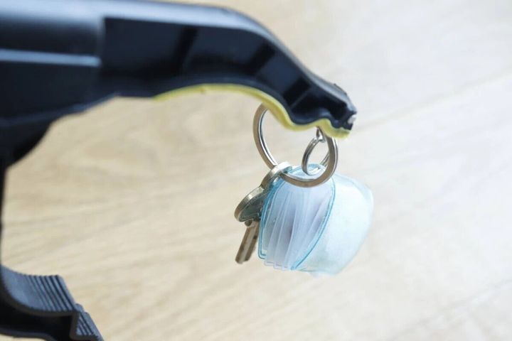 マジックハンドの先端で鍵とキーホルダーをしっかりと掴んでいる