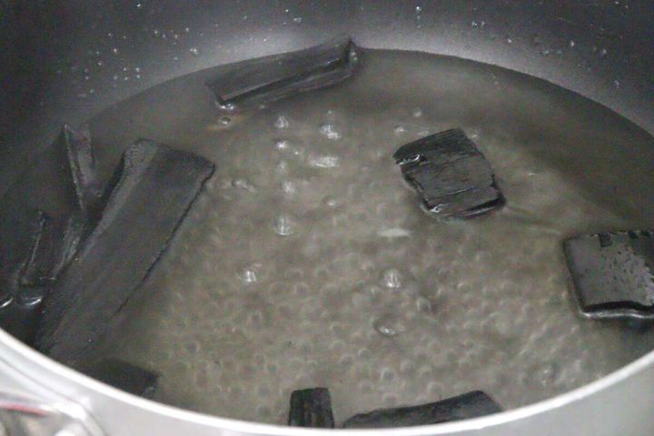 鍋で竹炭を煮沸消毒している様子、水が沸騰している