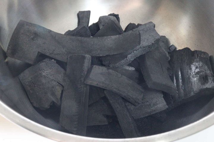 ステンレス製のボウルに様々な大きさの竹炭の塊が入っている