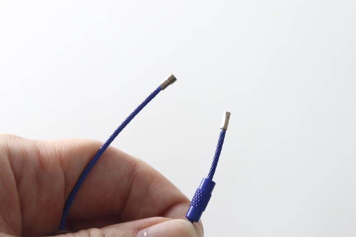 モーテルキーホルダーのネジ式ワイヤーを指で開いている様子
