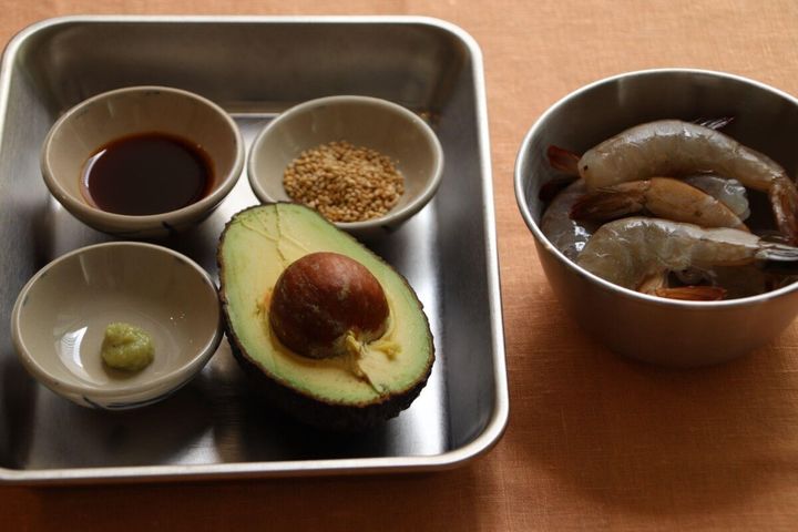 エビ、アボカド、醤油、わさび、炒りごまの材料が並べられた写真
