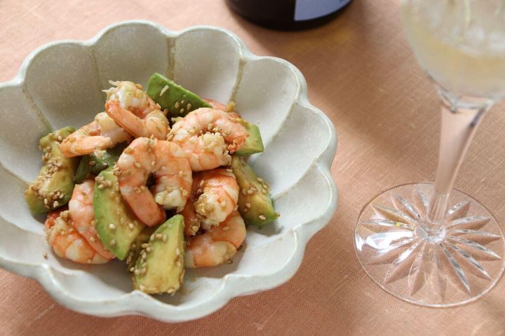 エビとアボカドのわさび醤油和えが盛り付けられた皿と白ワイングラス