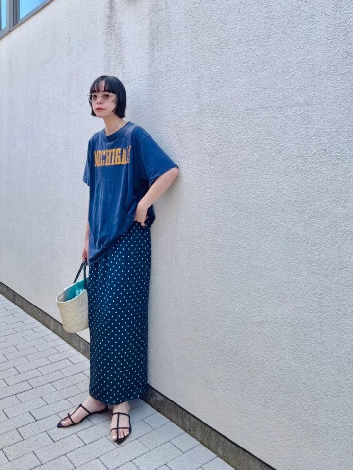ブルーTシャツとドット柄スカートの女性