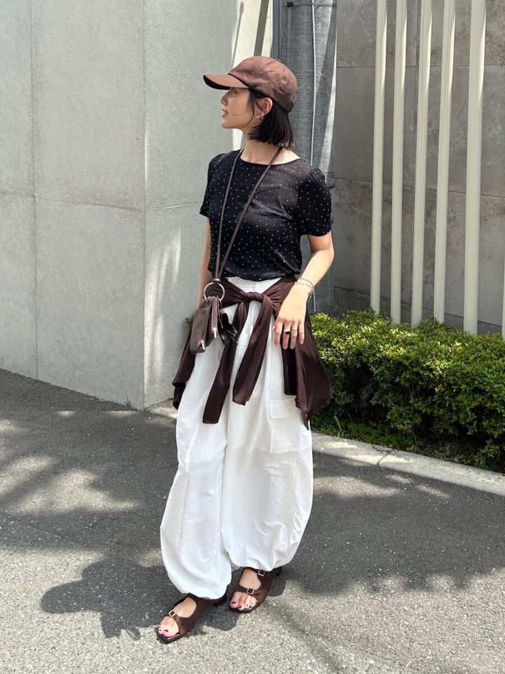 ドット柄Tシャツと腰巻きカーデの女性