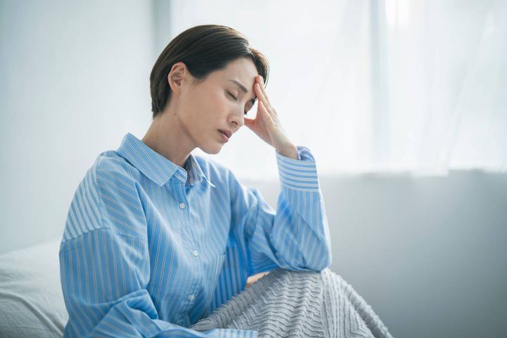 頭を押さえる女性