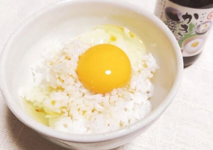 白いご飯の上に生卵が乗ったたまごかけご飯と、奥にかき醤油のボトル