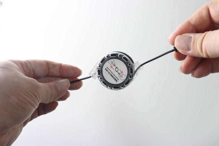両手でリール式ケーブルの両端を引っ張っている様子