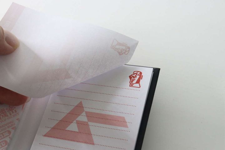 ブック型メモ帳のメモをめくっている様子。モアイ像のイラストが見える