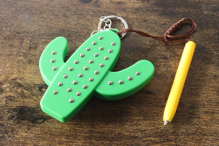 サボテン型キーホルダーの穴に鉄球が吸着している状態。横に黄色いペンが置かれている