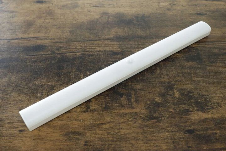 木目調のテーブルに置かれた白い人感センサー付きバーライト