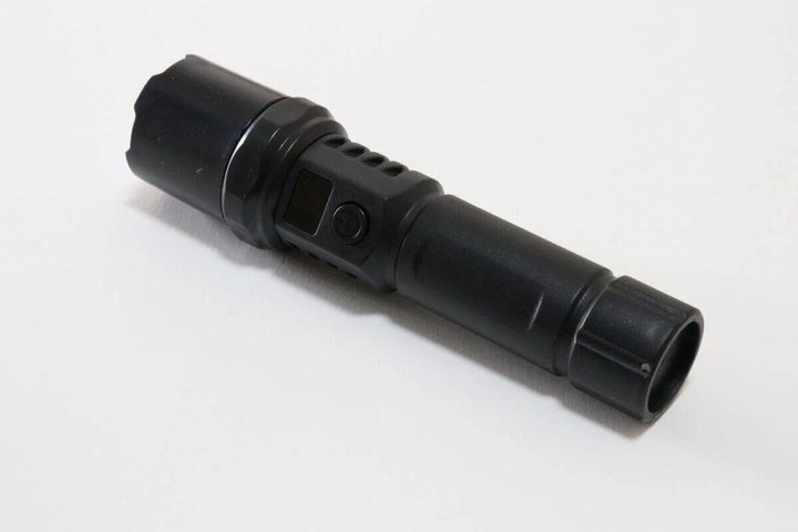 黒い充電式LEDライト（懐中電灯）が白い背景に置かれている
