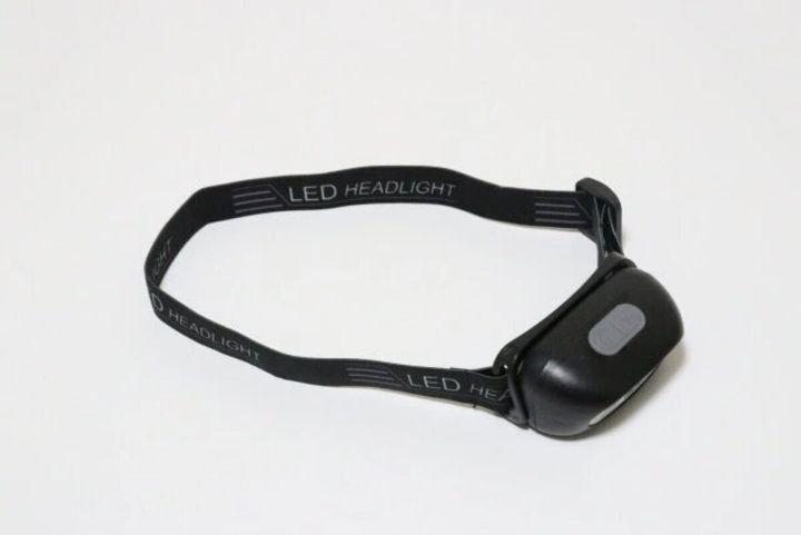黒いセンサー付きLEDヘッドライトが白い背景に置かれている
